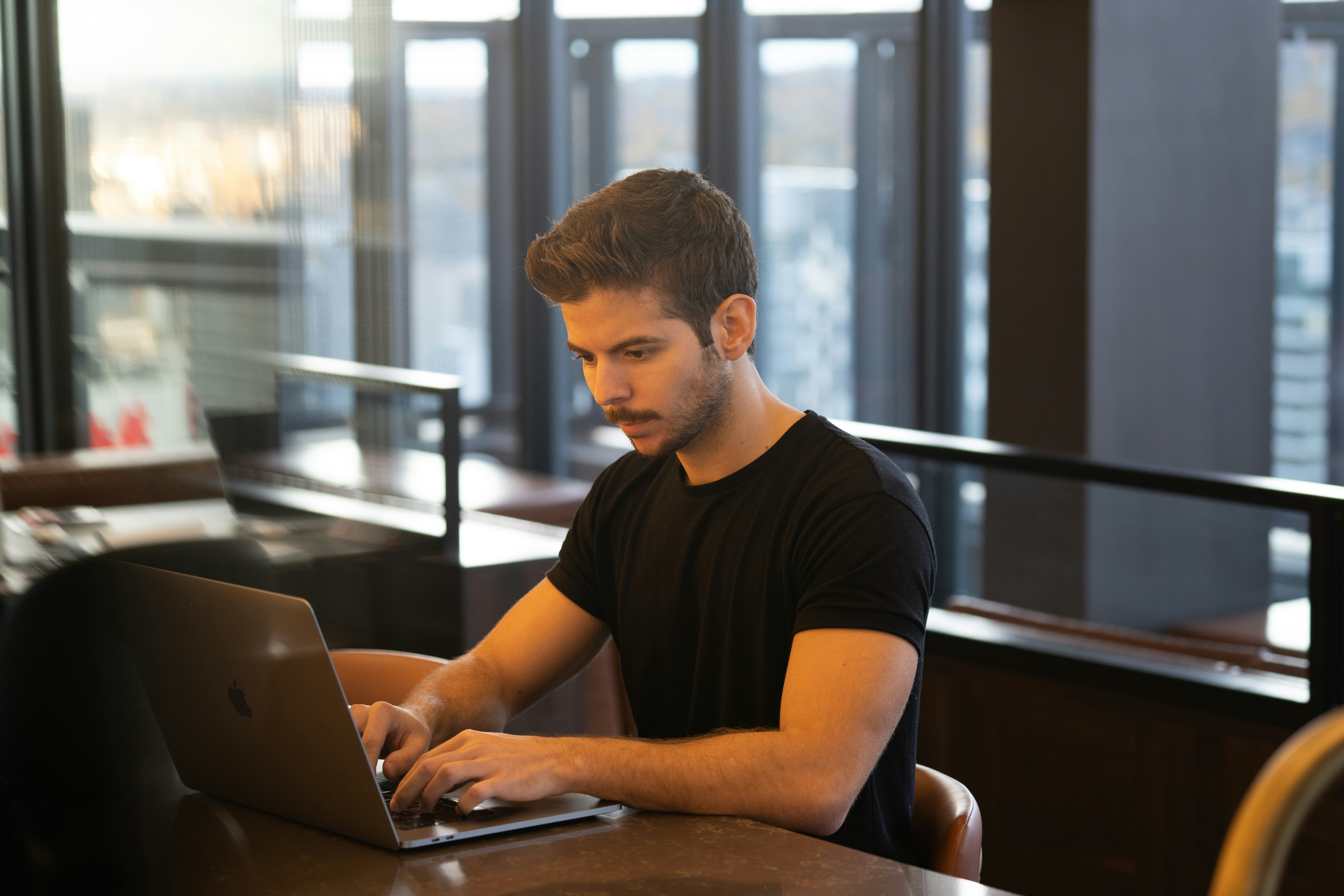 Schreibtisch mit Laptop, Kopfhörern und Buchstabensteinen, die das Wort LEARN bilden.